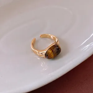 Gold-plated adjustable ring with oval tiger eye stone and hammered metal texture