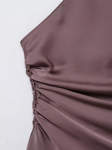 Detail of ruched deep purple satin fabric showing elegant draped texture and silk shine