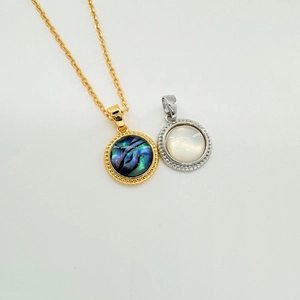 Detailed close-up of 18K gold and silver plated geometric shell pendants with zircon inlay