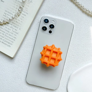 Dettaglio ravvicinato di un supporto per telefono a forma di waffle in silicone arancione
