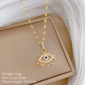 Close-up of gold evil eye pendant with tiny rhinestones on beige display box