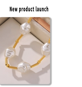 Close-up of gold titanium steel tube and irregular white pearls in a beige jewelry box