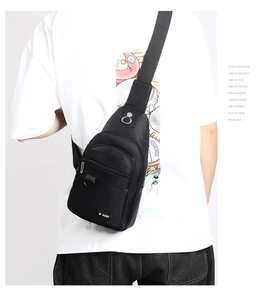 Rear view of man wearing a black waterproof oxford chest bag with multiple compartments