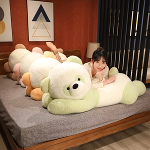 Traversin panda géant en peluche pastel sur un lit douillet dans une chambre