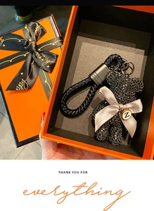 Detail of creative black rhinestone bear keychain with Z tag in orange gift box