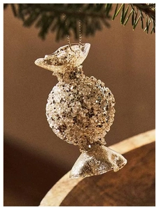 Detail of candy-shaped Christmas ornament with champagne sequins and beads on pine branch