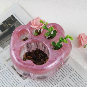 Detalle de maceta de resina de pata de gato con degradado rosa, purpurina y rosas