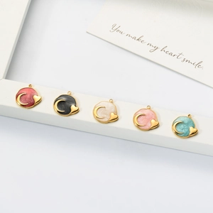 Detail of colorful celestial heart charms with gold edges and resin finish for jewelry making