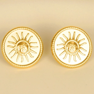 Macro detail of 18k gold plated stainless steel sun face relief earrings with a vintage finish