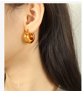 Close-up of golden chunky hollow hoop earrings in 18K gold plated minimalist style