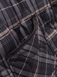 Détail de veste matelassée à carreaux avec motif gris foncé et poches latérales utiles