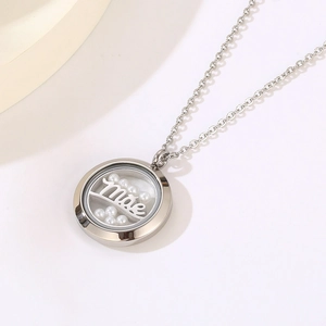 Close-up of silver round locket with Mãe inscription and white pearls on O-chain necklace