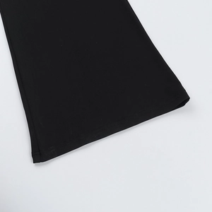 Detail of black mesh patchwork jumpsuit showing flared leg opening and refined hemline edge
