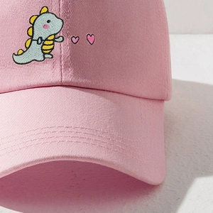 Pink cotton baseball cap featuring blue dinosaur and heart embroidery detail
