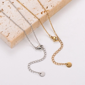Detail of 18k gold and silver necklace with lobster clasp, extender chain and metal texture