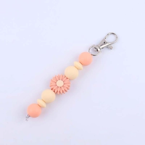 Detailed view of silicone bead keychain featuring a pink daisy and silver metal lobster clasp