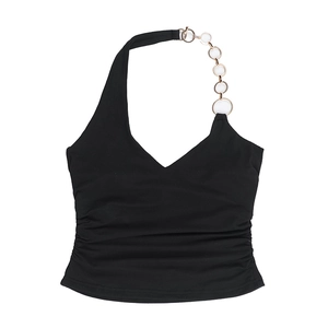 Détail d'un haut licou noir avec une chaîne en métal doré et une texture de tissu plissé