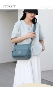 Close-up of lightweight nylon crossbody bag featuring multiple zipper pockets and brand logo