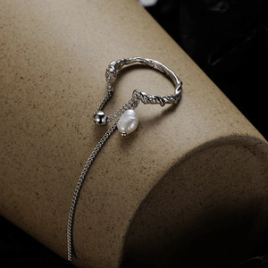 Macro shot of S925 sterling silver triple layer twisted ring with white pearl and fine chain