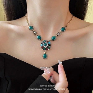 Vintage bronze necklace featuring multi-colored floral gemstones and a green teardrop pendant
