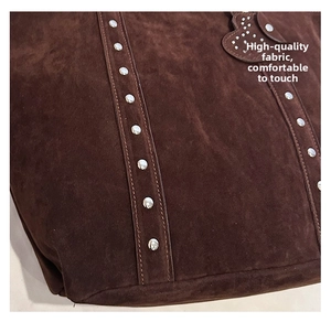 Detailed view of dark brown suede tote with silver metal rivets and scalloped trim edge