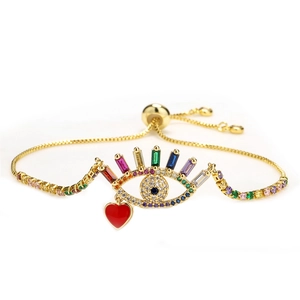 Adjustable gold evil eye bracelet with colorful zircons and a red heart charm dangle