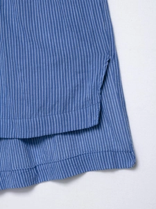 Gros plan sur la fente latérale d'une chemise à rayures bleues avec coutures précises