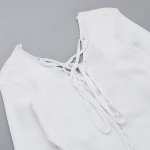 Detailed view of white ribbed knit dress neckline with elegant cross lace-up detail