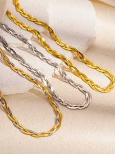 Detail showing woven flat snake chain necklaces in gold, silver, and tricolor finishes