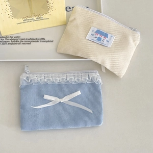 Dettaglio del borsellino in velluto a coste azzurro con pizzo bianco e fiocco chic