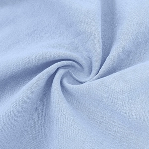 Macro shot of breathable periwinkle blue linen fabric texture with soft spiral folds