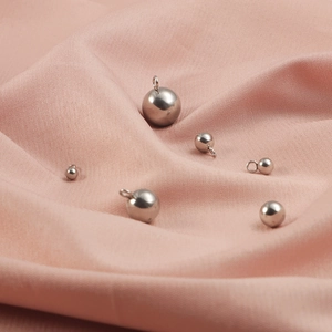 Pendenti a sfera in acciaio inossidabile lucido in varie misure su tessuto rosa