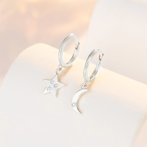 Detail of asymmetric S925 silver star and moon hoop earrings with cubic zirconia