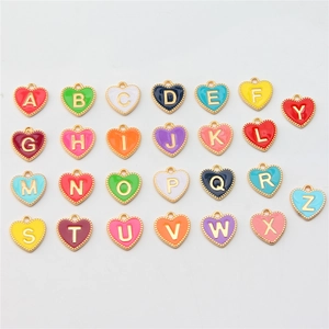 Flat lay of 26 colorful heart-shaped enamel alphabet charms with golden metal edges