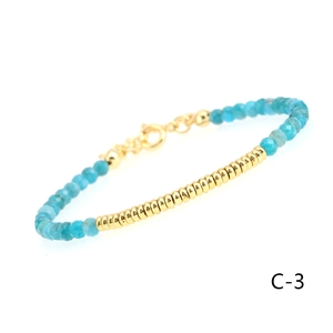 Detailed close-up of blue faceted gemstone beads and textured gold tube on the bracelet