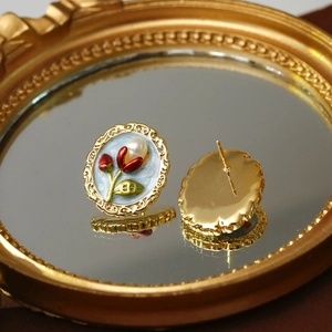 Vintage Baroque natural pearl studs with red enamel rose and gold frame on mirror
