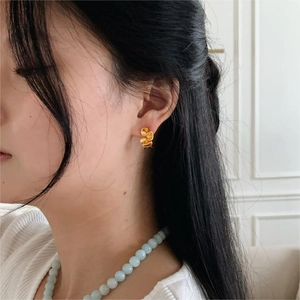 Minimalist golden flower petal stud earrings worn by a model in a trendy Korean ins style