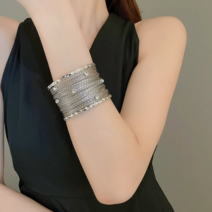 Detail of silver multi-layer wire bracelet with sparkling rhinestones on model arm