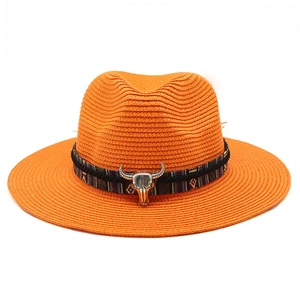 Dettaglio cappello fedora arancione con fascia etnica e ciondolo testa di toro in metallo