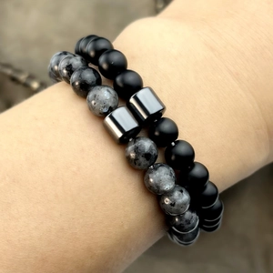 Detailed macro view of double-layer beaded bracelets with matte black and spotted natural stones