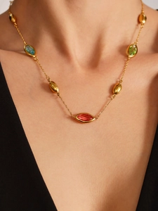 Detailed close-up of colorful marquise gemstones and golden beads on 18k gold necklace