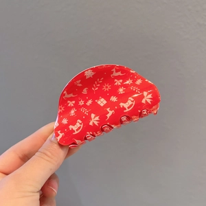 Red Christmas claw clip featuring white reindeer and snowflake motifs for festive hair styling