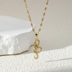 Gold-tone snake pendant necklace with shimmering zircons and red gemstone eyes
