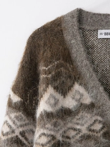 Macro shot of V-neck knitted cardigan showing jacquard pattern and textured mohair fiber