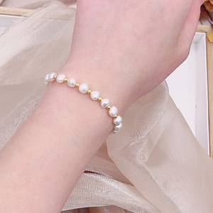 Close-up of fresh water pearls and gold metal beads bracelet on a woman's wrist