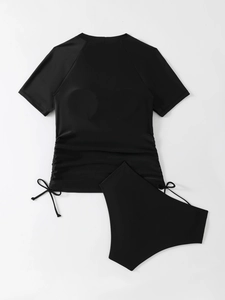 Detail of black two-piece tankini set featuring adjustable side drawstrings and raglan sleeves