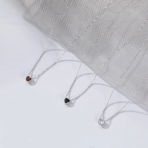 Elegante Herzanhänger-Halsketten in Rot, Schwarz und Weiß auf silbernen Gliederketten