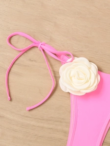 Detail showing the 3D cream white flower on bright pink bikini with fine stitching