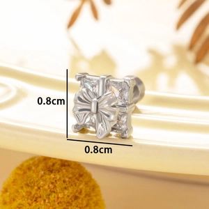 Silver bow-tied gift box stud earring with sparkling cubic zirconia on warm background