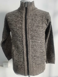 Detail of grey-brown thick knit sweater with full-zip stand collar and ribbed texture